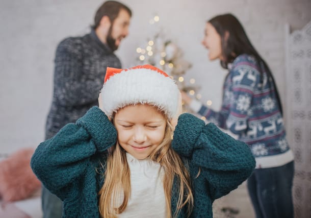 upset girl with parents fighting at christmas