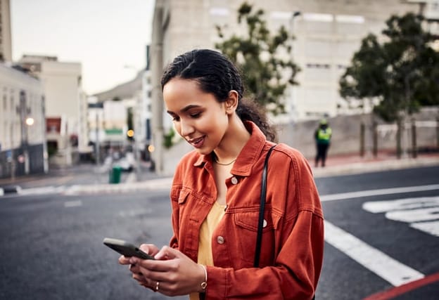 happy woman texting on street