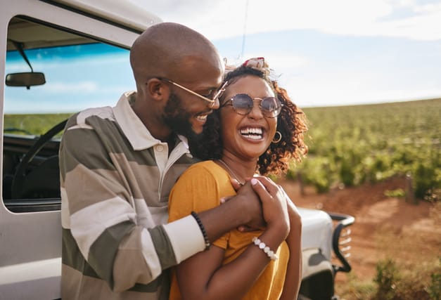 happy Black couple embracing at vineyard