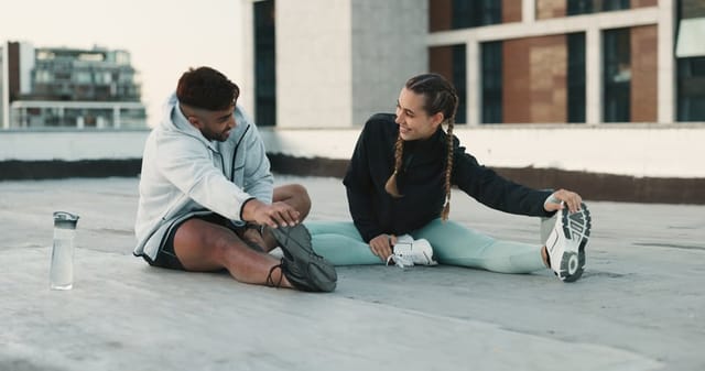 Fitness, couple and stretching body on rooftop in workout, exercise or outdoor training together. Happy man and woman in warm up or getting ready for cardio, practice or sports preparation in city
