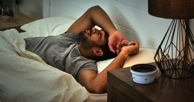 Thinking, depression and asian man in a bed with insomnia, fatigue or sleep paralysis anxiety. Burnout, conflict and male person in a bedroom with overthinking stress, ptsd or mistake trauma in house