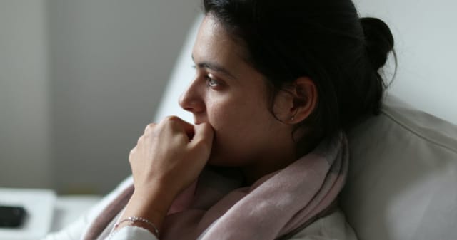 Woman biting her nails in nervousness.