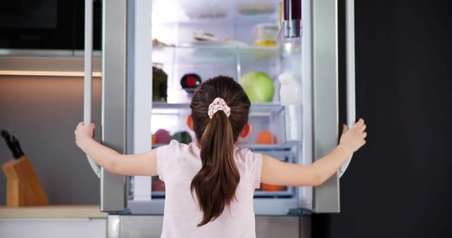 Girl checking the fridge.