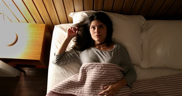 Worried woman unable to fall asleep.