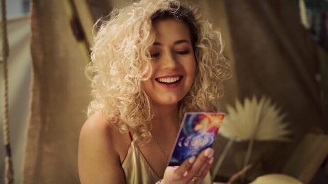 woman smiling at tarot card