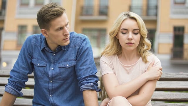 Angry boyfriend looking at sad girlfriend, woman feeling guilty, conflict