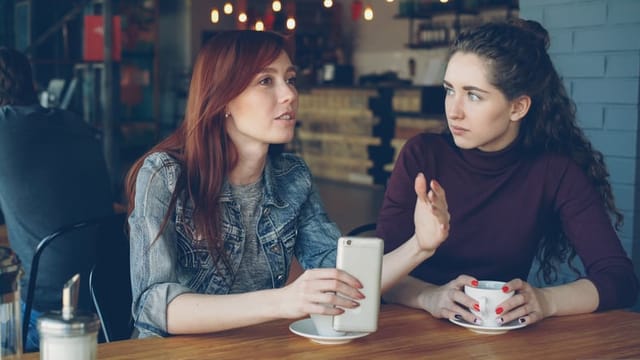 two female friends talking in a coffee shop