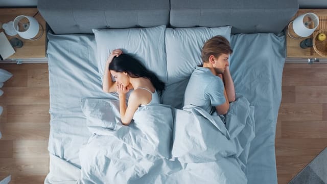 couple back to back in bed
