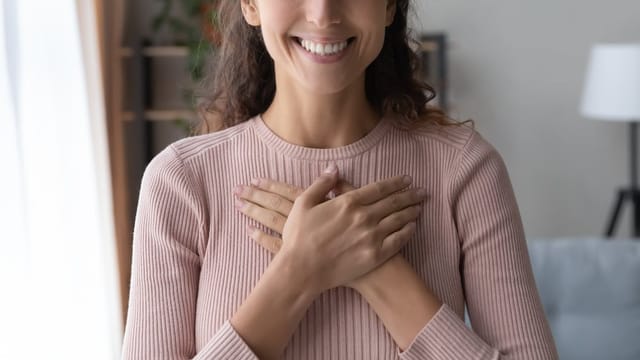 Woman with her hands on her heart.