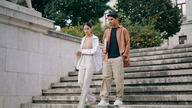 man and woman walking down stairs outside