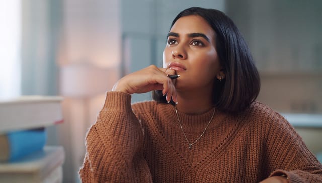 woman looking pensive pen in hand
