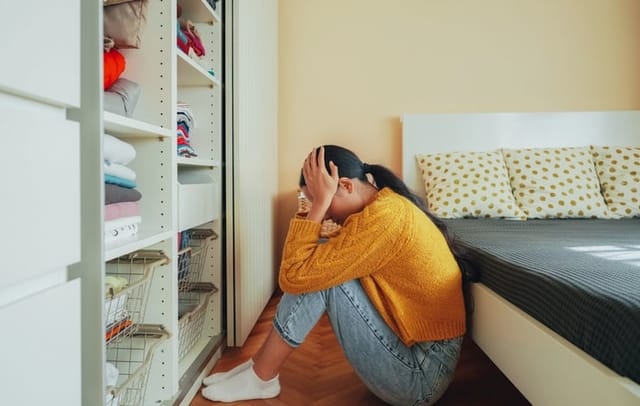 upset woman sitting in bedroom