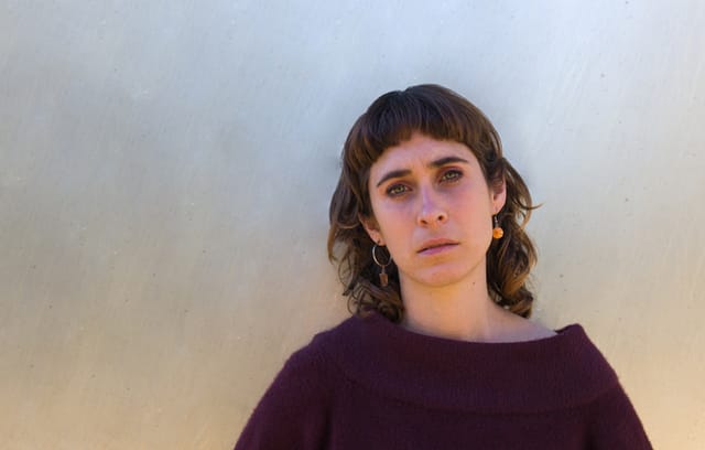 serious woman standing against wall