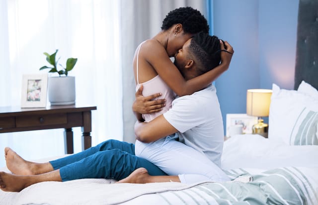 couple passionately embracing in bed