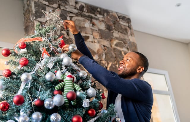 man putting up christmas decorations