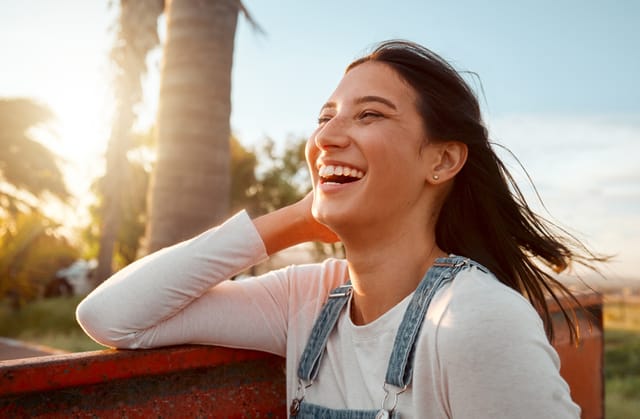 smiling woman in sunshine outdoors