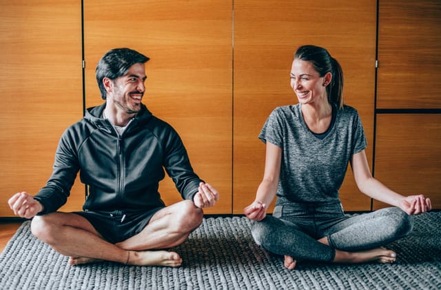 couple meditating and smiling