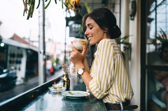 smiling woman with coffee at cafe bar