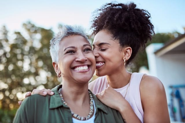 happy adult woman with mom smiling outside