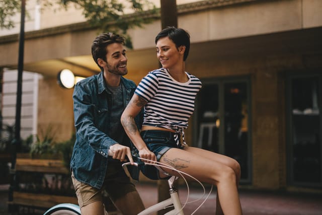 man woman riding bike outside