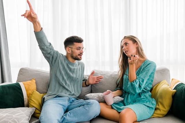 annoyed couple arguing on couch