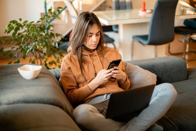 woman texting on couch