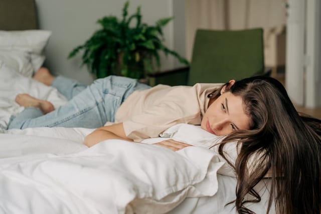 sad woman lounging in bed