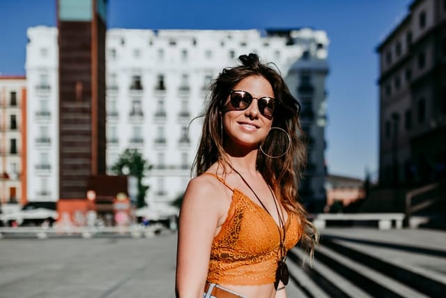 smiling woman in sunglasses in city