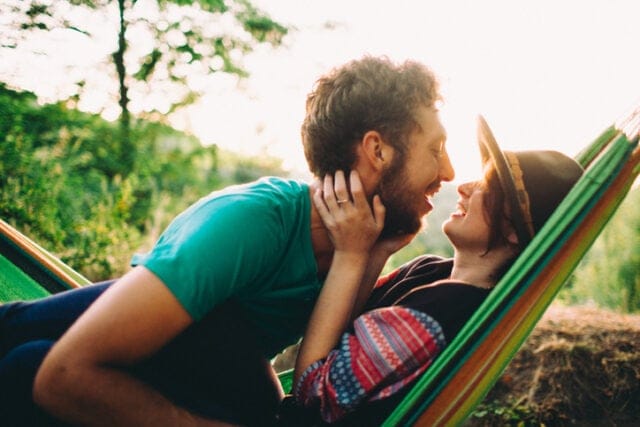 happy couple kissing on hammock