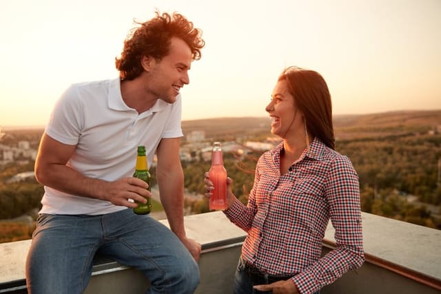 couple drinking beer on rooftop