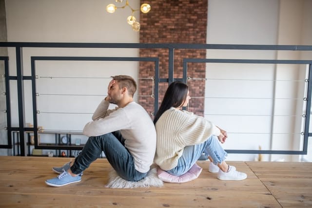 couple sitting on floor looking in opposite directions