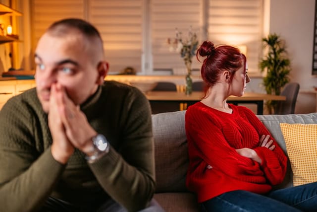 couple looking away from each other on the couch