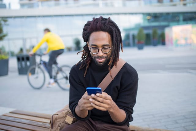 Black man texting city center