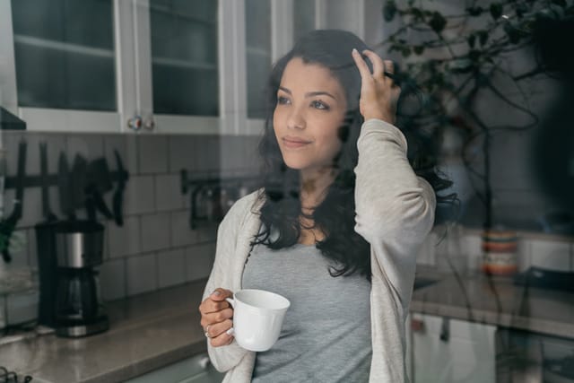 woman drinking coffee in kitchen