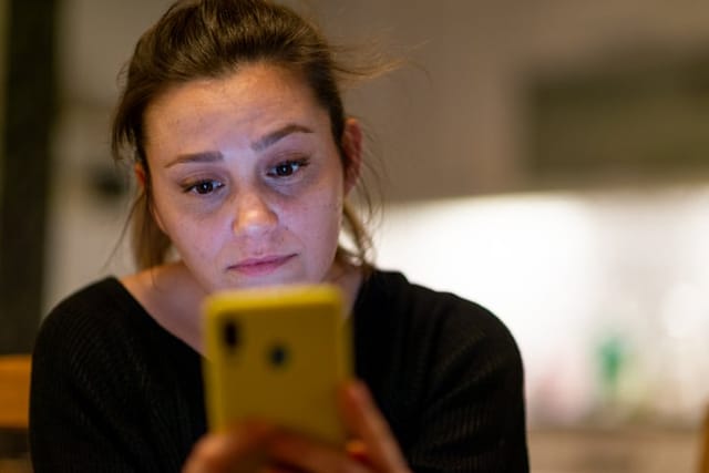 stressed woman looking at smartphone