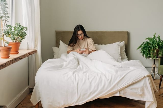 woman texting while in bed