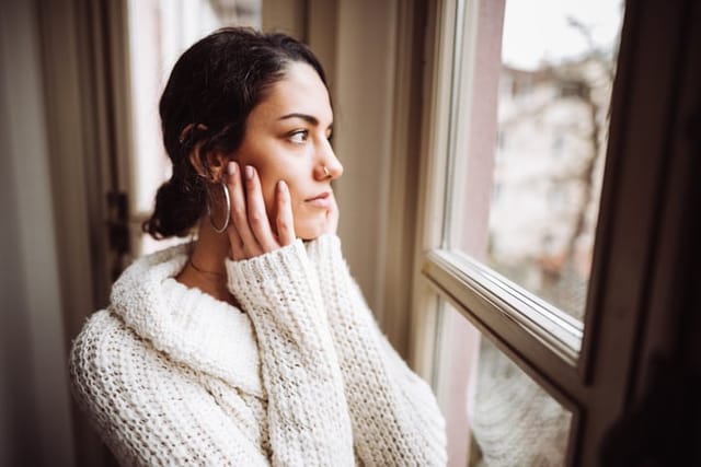 sad woman looking out window