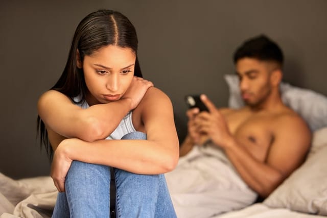 upset woman in bed with boyfriend