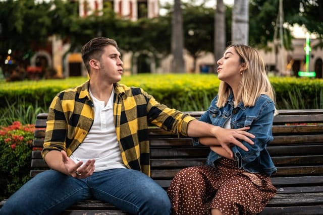 young couple arguing on bench