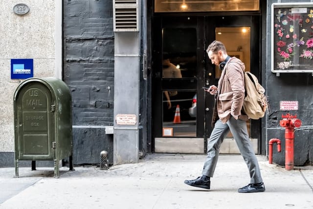 guy texting while walking NYC