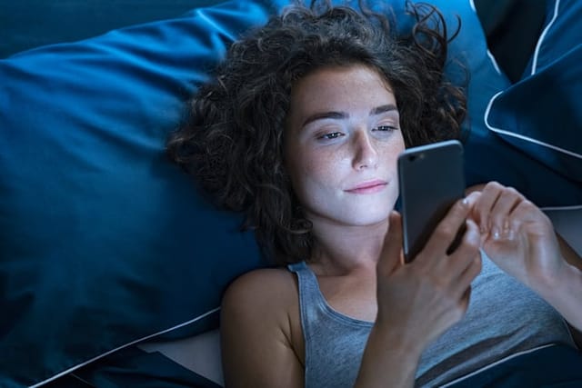 woman texting in bed at night