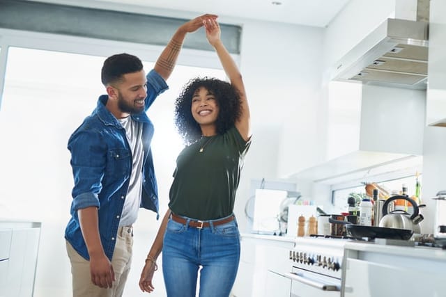 couple dancing happily in kitchen