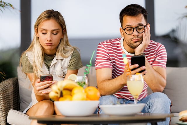 bored couple on couch on phones