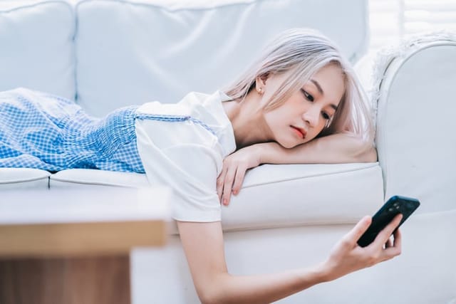 woman staring at phone on couch