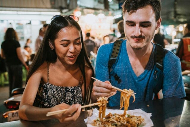 couple eating noodles on vacation