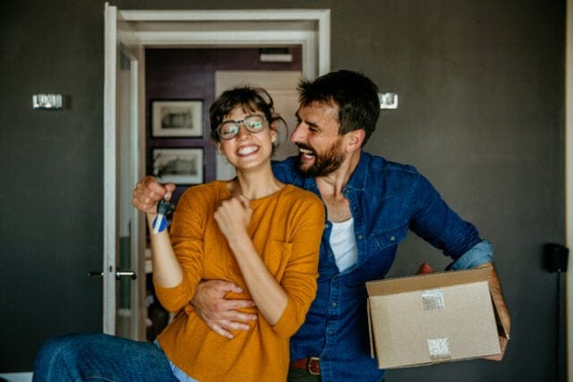 happy couple moving into apartment