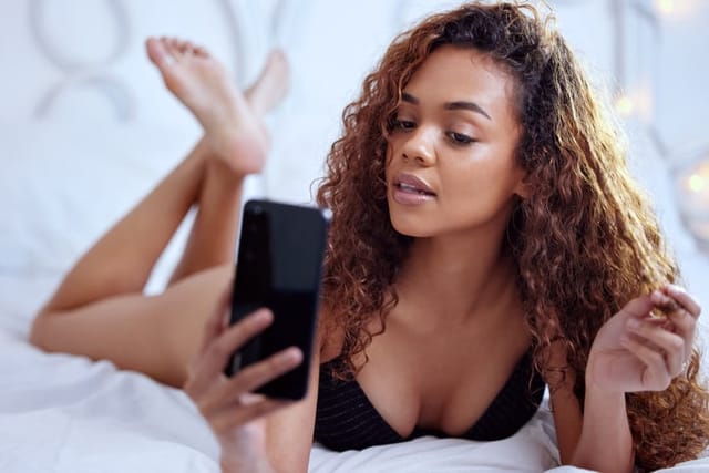 woman taking selfie in bed