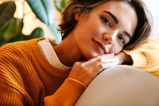 smiling brunette woman orange sweater