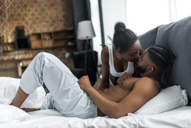 black couple kissing in bed