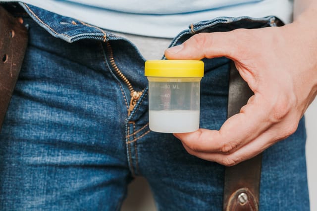 man holding sperm donation container